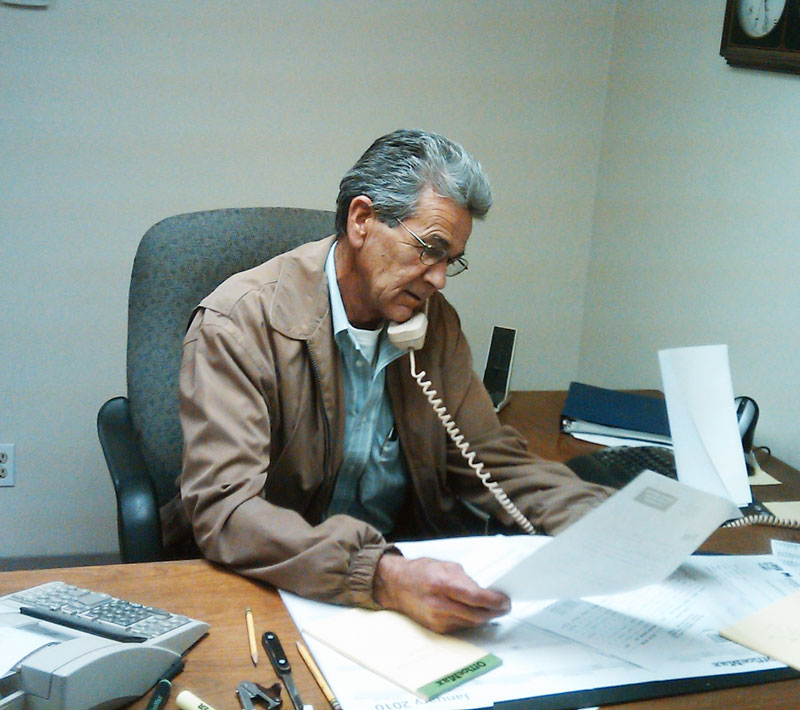 Sid Wheeler sitting at desk talking on the phone